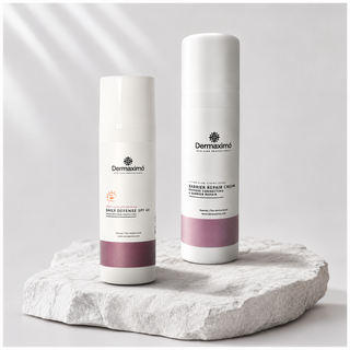 Two Dermaximó skincare bottles displayed on a light stone slab against a soft white background with diagonal shadows. One bottle is white with a mauve band and reads 'Daily Defense SPF 40', and the other is a taller white bottle with a mauve band and reads 'Hair Repair Cream'.
